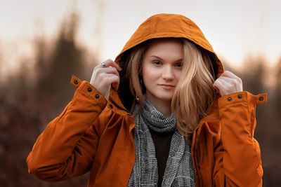 Portrait of young woman standing against plants