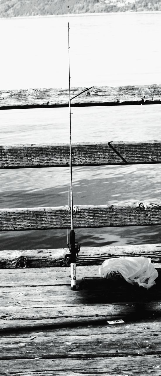 MAN FISHING ON BEACH AGAINST SKY