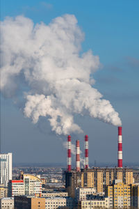 Smoke emitting from chimney against sky