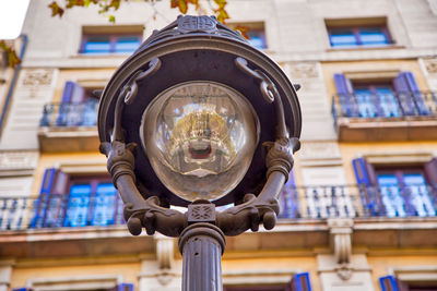 Low angle view of electric lamp on building