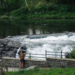 Man standing by waterfall