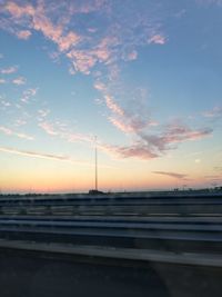 Bridge over road against sky during sunset