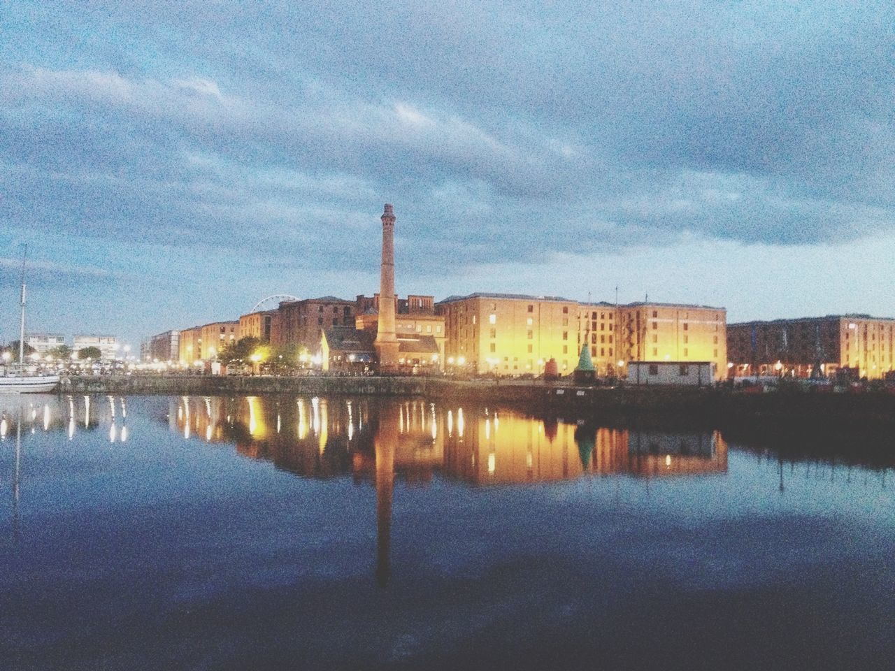 architecture, building exterior, built structure, water, reflection, sky, city, waterfront, tower, river, cloud - sky, lake, tall - high, cloud, dusk, cityscape, sunset, outdoors, skyscraper, travel destinations