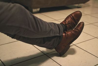Low section of man sitting on tiled floor