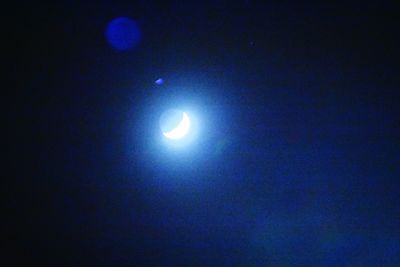 Low angle view of moon against clear blue sky