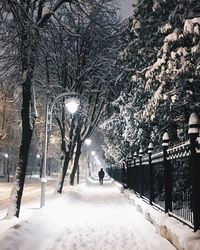 Man walking on snow covered street in city