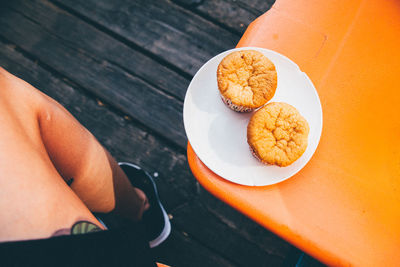 Low section of person sitting with muffins