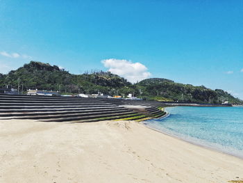 Scenic view of beach against blue sky