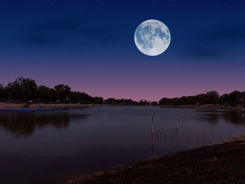 Scenic view of lake against sky at night