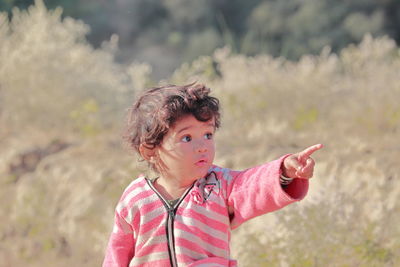 A small beautiful indian-origin child in the forest with a hand gesture telling something, india