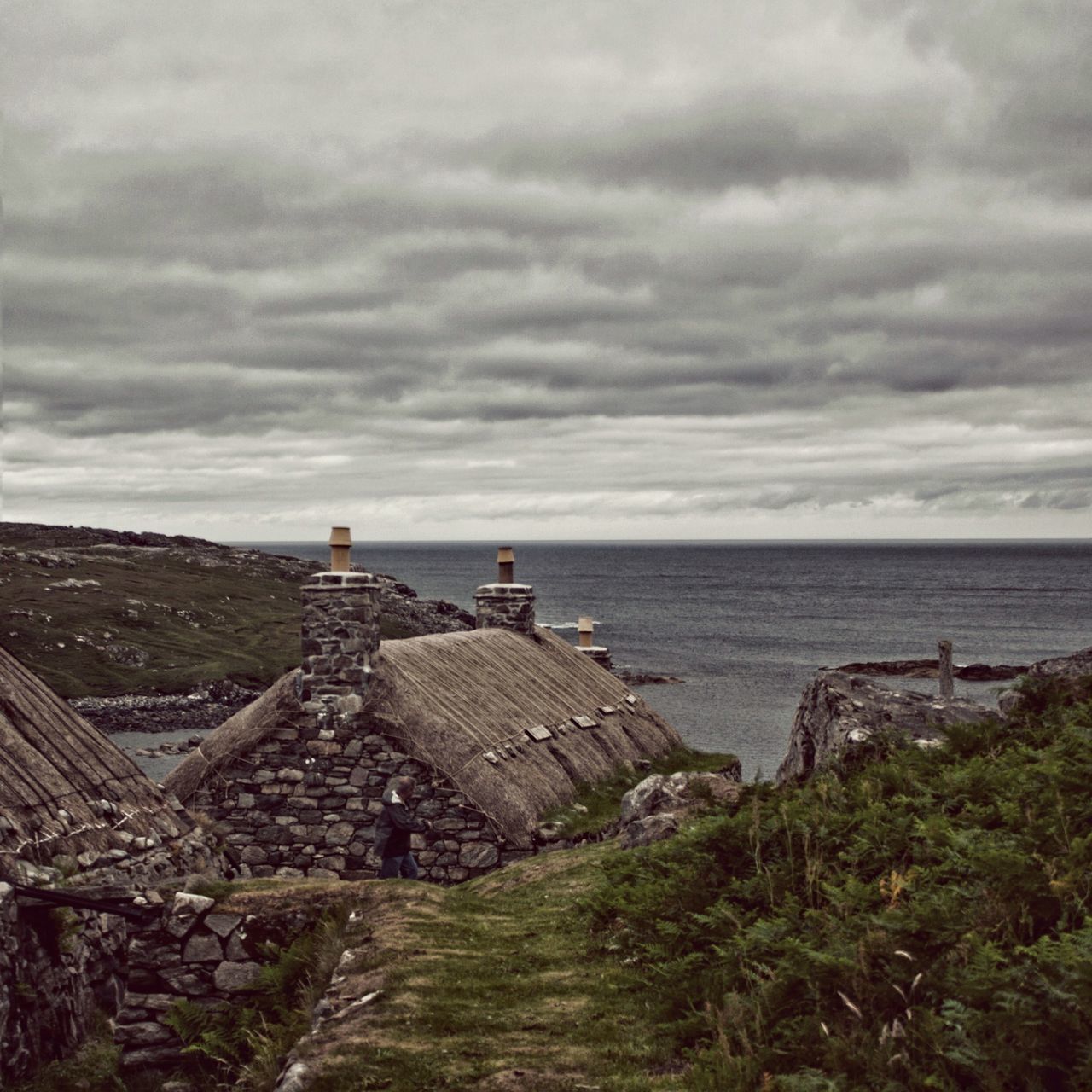 sea, horizon over water, sky, water, cloud - sky, tranquil scene, cloudy, tranquility, built structure, scenics, nature, architecture, beauty in nature, rock - object, cloud, grass, building exterior, day, lighthouse, idyllic