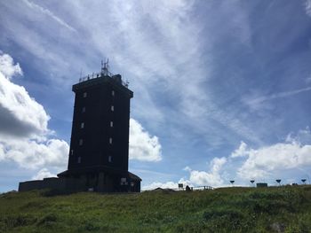 Low angle view of lighthouse on field against sky