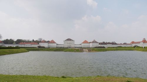 Scenic view of river by buildings against sky