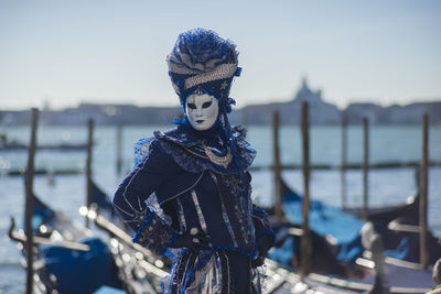 Person wearing mask against grand canal during carnival