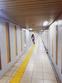 Rear view of woman standing in corridor