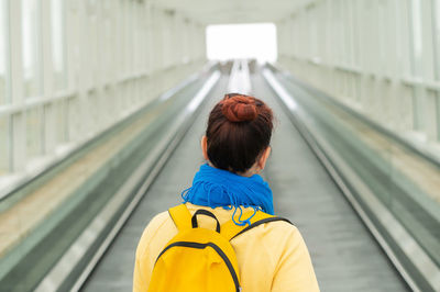 Rear view of woman with umbrella standing on railway station