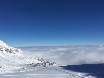 Scenic view of snowcapped mountains against blue sky