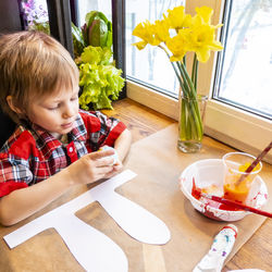 High angle view of cute girl with flowers on table