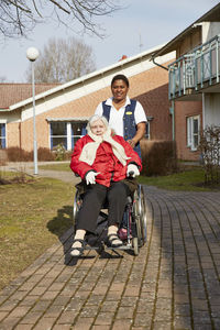 Nurse on walk with senior woman on wheelchair