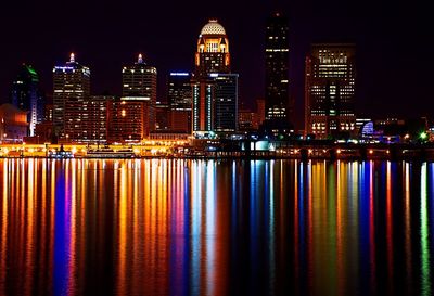 Reflection of illuminated colorful light on ohio river against buildings at night