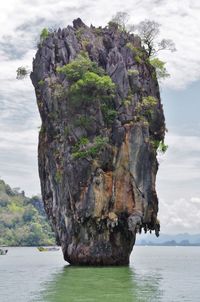 Scenic view of cliff by sea against sky