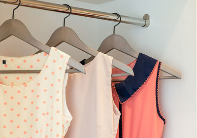 Close-up of clothes hanging on rack against wall