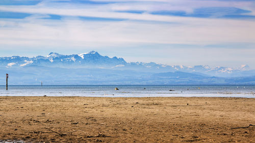 Scenic view of beach against cloudy sky