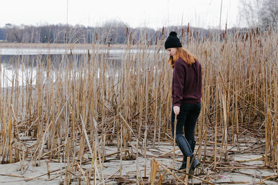 Full length of woman standing on field during winter