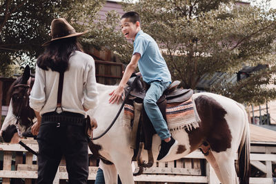 Rear view of men riding horse