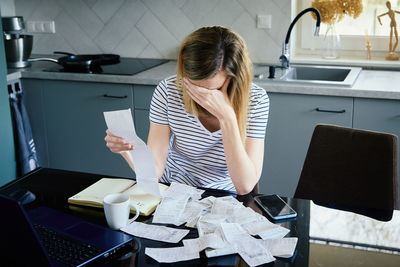 Woman calculating payment bill at home