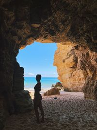 Rear view of woman standing on rock formation