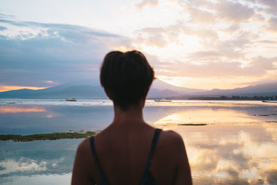 Rear view of woman looking at sea against sky