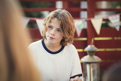 Teenage boy looking away in back yard