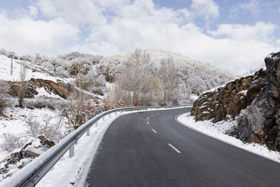 Road amidst snowcapped mountains against sky