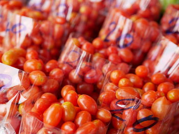 Selective focus of clean fresh small red tomatoes in a plastic bags for sale 