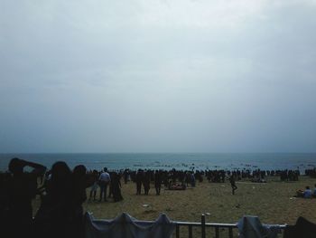 People at beach against sky