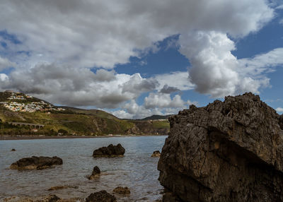 Rocks by sea against sky