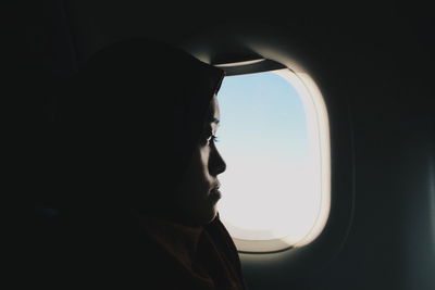 Woman looking through airplane window