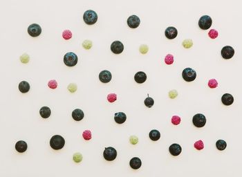 High angle view of multi colored candies against white background