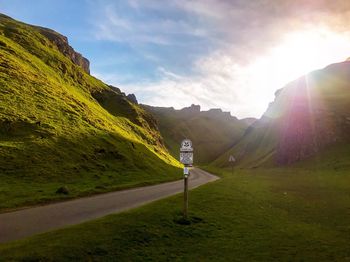Road leading towards mountains against sky