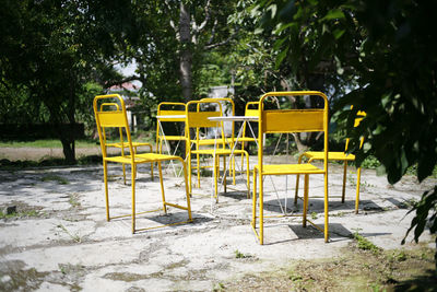 Empty chairs and table in park