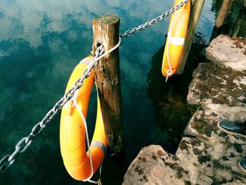 High angle view of life belts hanging on wooden posts over calm lake