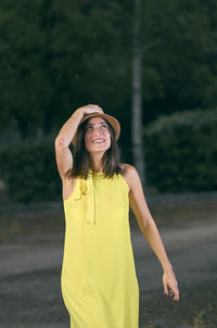 Young woman standing against yellow water