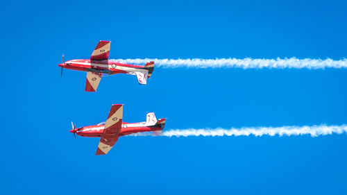 Low angle view of airplane flying against blue sky