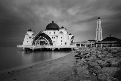 Melaka straits mosque over sea against cloudy sky