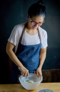 Close-up of woman preparing dough in bowl at table