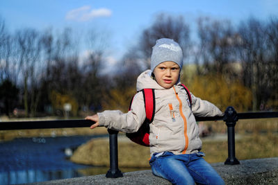 Boy relaxing on retaining wall