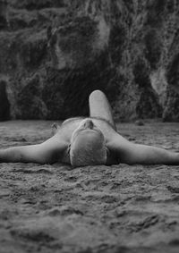 Monochrome of shirtless adult man lying on beach