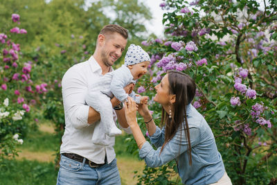 Happy young family is having fun and walking in a blooming spring park