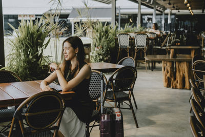 Woman sitting on table in restaurant